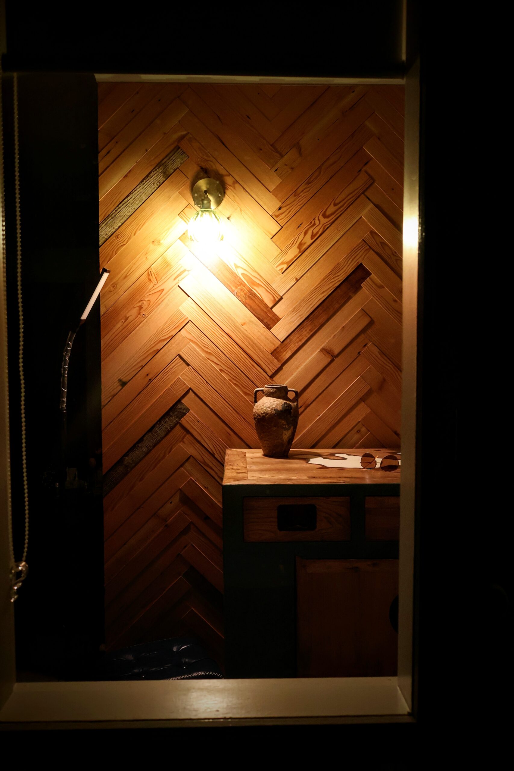 Architectural herringbone timber feature wall with ambient lighting and custom entry cabinet in Wollongong NSW