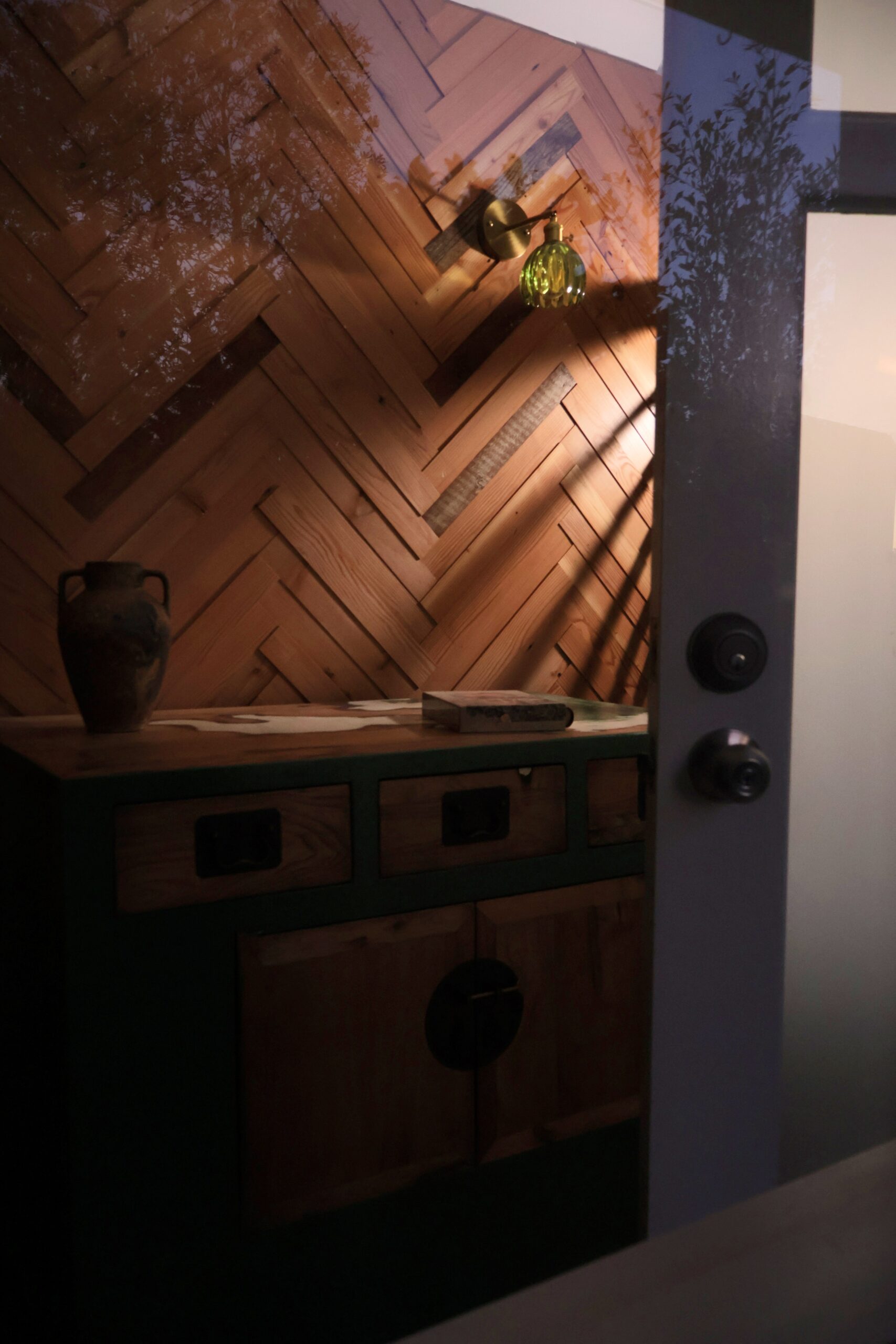 Custom timber herringbone feature wall with warm lighting and handcrafted entry unit in Wollongong NSW