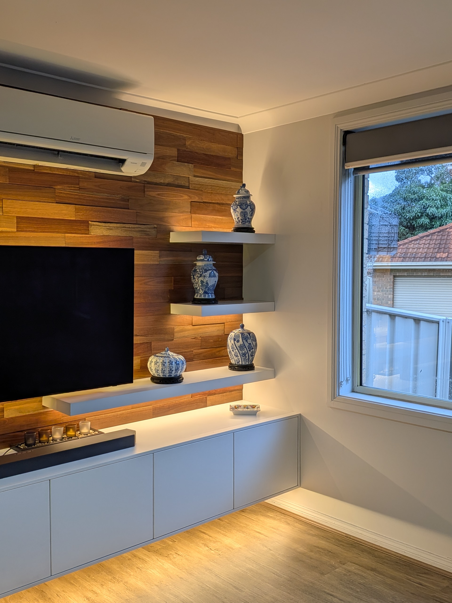 Custom timber feature wall with integrated TV unit and vertical wood panelling in Shellharbour