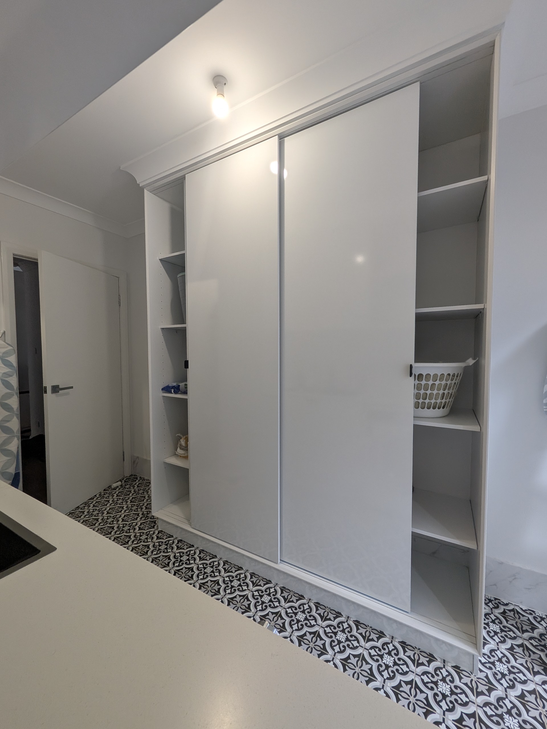 Modern built-in wardrobe with white gloss sliding doors and soft minimalist finish in Shellharbour