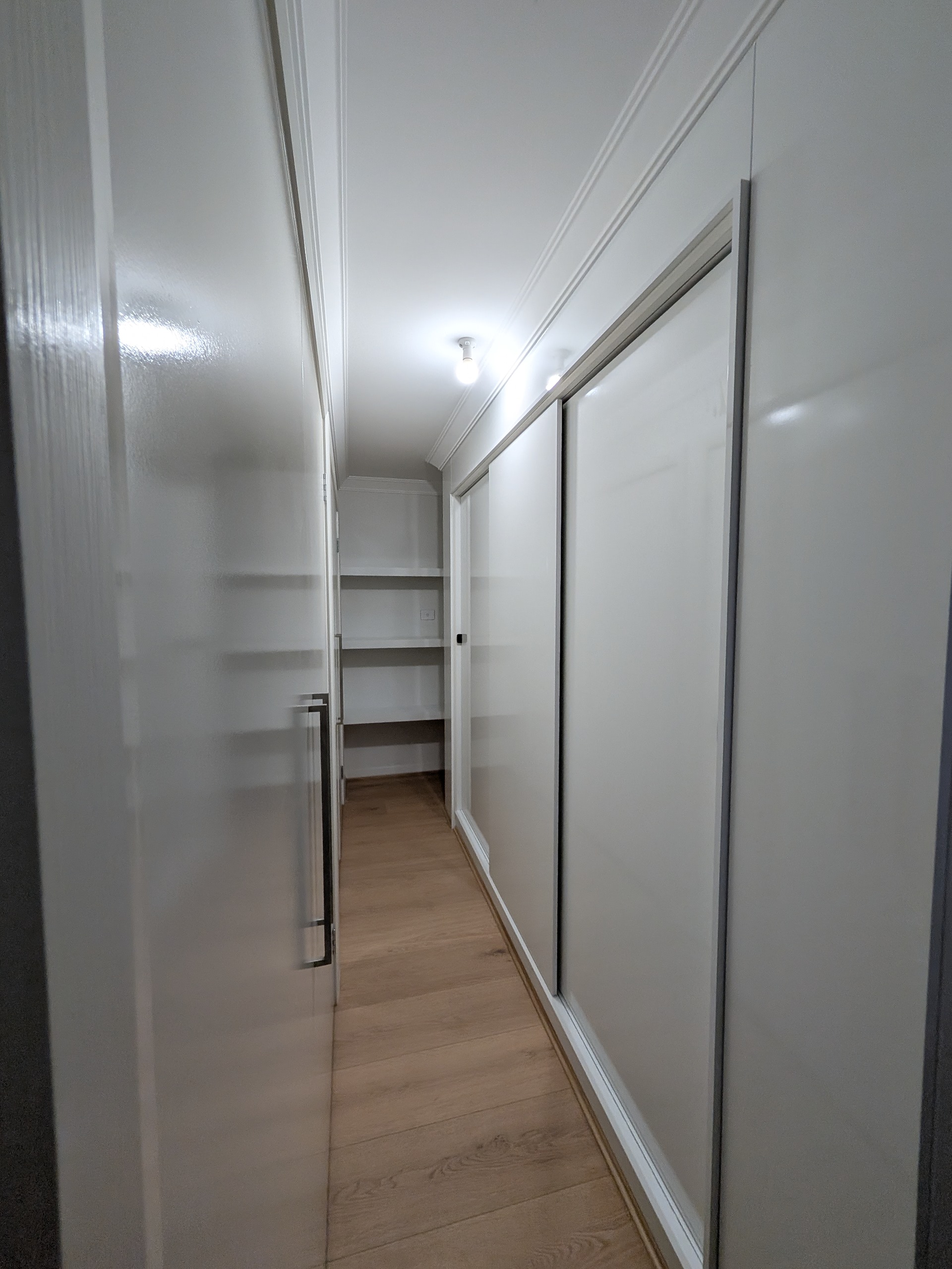 Custom storage cabinet and sliding wardrobe system designed for narrow hallway spaces in Shellharbour